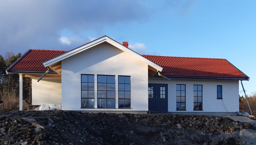 Villa med vit fasad och rött tak i referensprojekt med EcoNordic