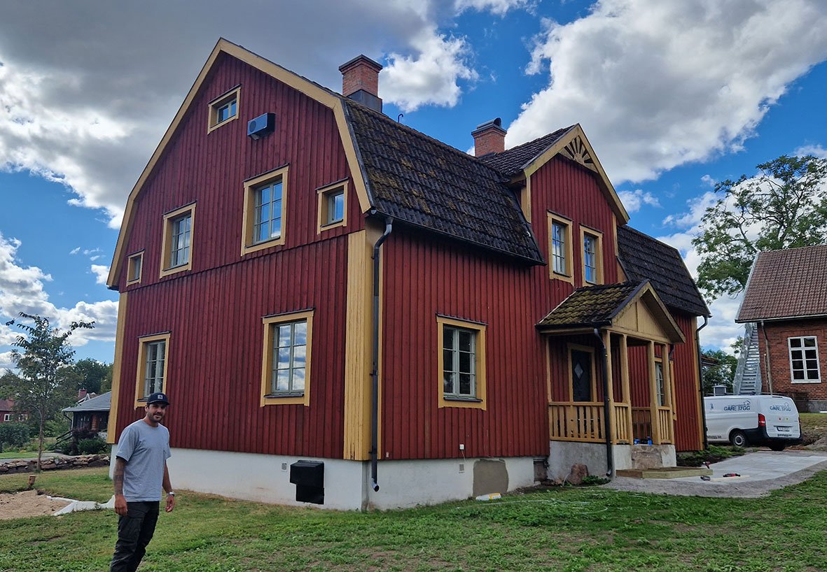 Röd förskolebyggnad i två plan med traditionell arkitektur