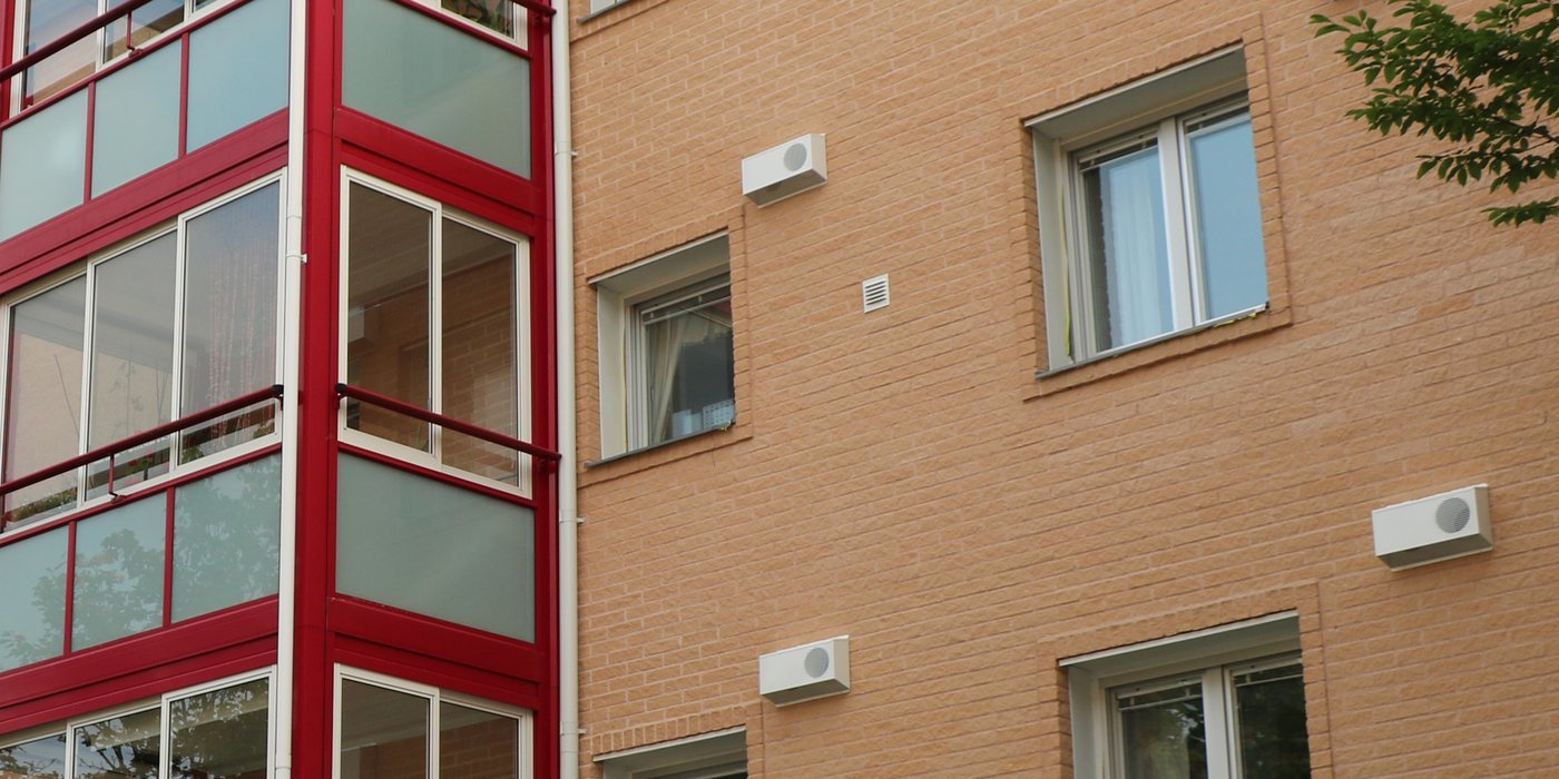 Fasade på leilighetsbygg med kombiboks for avkastluft og uteluftinntak montert i fasaden.