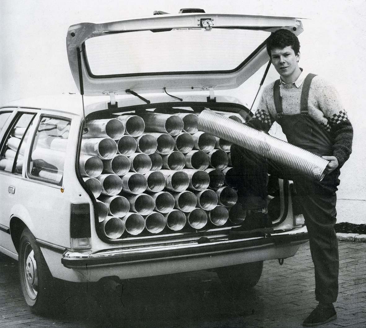 Pål Martinssen laster ventilasjonskanaler inn i bagasjerommet på bil tidlig i Flexits historie